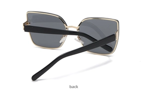 Side-back detail of oversized square cat-eye sunglasses with gold and black metal frames