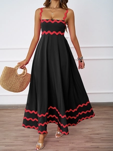 Detail of black summer maxi dress with red scalloped trim and elegant A-line silhouette