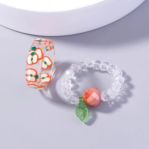 Detailed view of two crystal fruit rings featuring red apple patterns and faceted beads