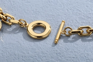 Detailed view of the gold OT toggle clasp and geometric chain links of the bracelet