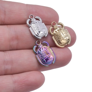 Macro detail of 304 stainless steel beetle pendants in gold, silver and rainbow finish