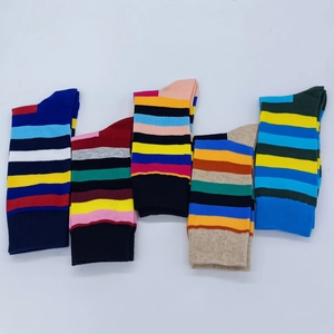 Flat lay macro of five pairs of colorful striped cotton crew socks for men with ribbed texture