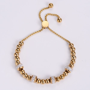 Adjustable golden beaded bracelet with shimmering crystal pave balls on white background