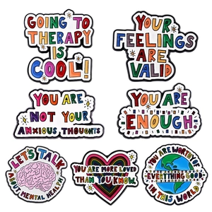 Set of 7 inspirational mental health enamel pins with motivational quotes and colorful designs