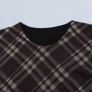Gros plan du col rond et du motif à carreaux en tricot sur la robe à manches longues