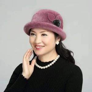 Close-up of purple faux fur winter basin hat with decorative leaf and pom-pom for women