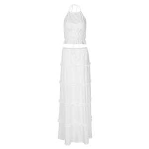 Detail view of a white two-piece set featuring a halter top and tiered maxi skirt