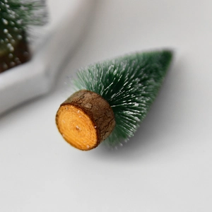 Mini tabletop snowy Christmas tree with green needles and natural wood base decor
