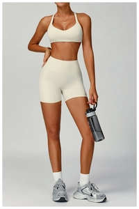 Vue de face d'un ensemble de sport blanc crème avec brassière dos nageur et short taille haute