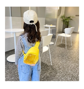 Detail of yellow PVC kids chest bag with transparent sequin window and nylon strap