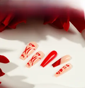 Close-up of long coffin press-on nails with red hearts, red lips and XO patterns