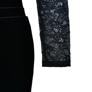 Détail de robe noire avec manches en dentelle florale et tissu en velours texturé