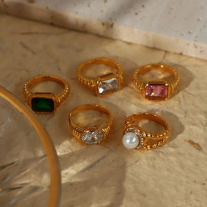 Detail der vintage 18K vergoldeten Ringe mit Zirkonia und Perlen auf Steinplatte