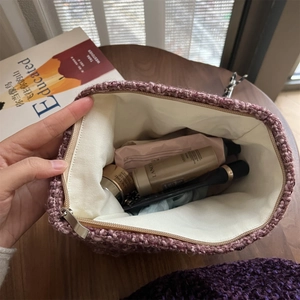 Detailed view of spacious interior storage for a purple tweed knitted cosmetic bag