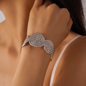 Vue détaillée d'un large bracelet argenté avec motifs spirales en relief et texture