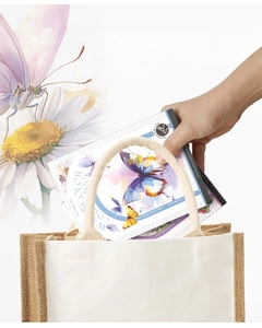 Portable tri-fold watercolor coloring book with butterfly patterns being placed in a bag