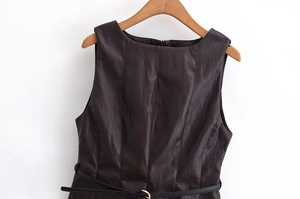 Détail d'une robe sans manches en similicuir marron foncé avec ceinture noire sur cintre