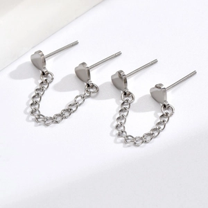 Detailed view of silver heart stud earrings with integrated double chain connector
