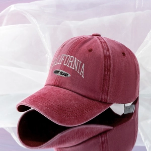 Detailed embroidery of California West Coast text on a washed red cotton baseball cap
