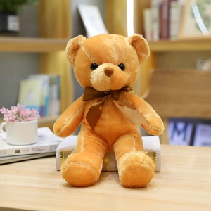 Oso de peluche marrón con lazo de seda sentado en un escritorio acogedor con luz natural