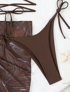 Detailed flat lay of a brown bikini and matching marble pattern mesh sarong beachwear set