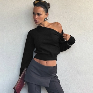 Détail d'un haut en tricot noir ajusté avec un col oblique chic et des manches longues