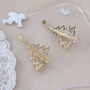 Golden Christmas tree earrings with star studs on elegant pink satin and lace background