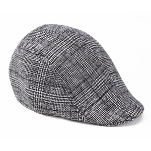 Close-up of vintage black and white houndstooth flat cap with thick wool texture