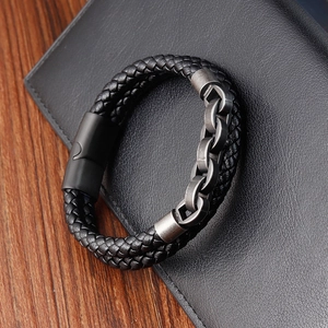 Detail of black braided leather bracelet with dark grey metal chain and magnetic clasp