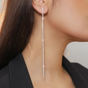 Close-up of long silver linear tassel earrings with sparkling rhinestones on a model