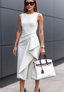 Detail of elegant white sleeveless dress showing tailored waist and pleated fabric texture