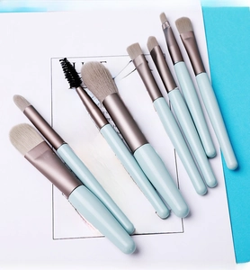 Detail of 8-piece light blue makeup brush set with soft fibers on decorative card