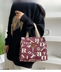 Détail du sac à lunch bordeaux en tissu Oxford avec imprimé lettres et poignée résistante