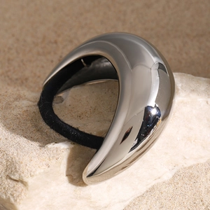 Minimalist elastic hair tie with silver metallic accent on natural stone background