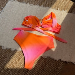Bikini taille haute dégradé coucher de soleil avec haut croisé sur tapis tressé