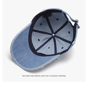 Detail view of adjustable metal buckle and inner sweatband on light denim baseball cap
