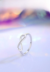 Detailed close-up of a silver infinity symbol ring with delicate micro-pave crystals