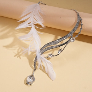 Detail shot of luxury feather necklace with oval rhinestones and silver wave metalwork
