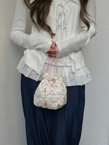 Quilted drawstring storage bag with cute cartoon bear and strawberry prints being held