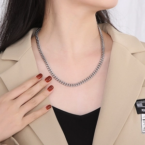 Silver stainless steel Cuban link chain necklace shown on male model with professional attire