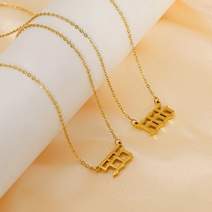 Close-up of 18K gold-plated stainless steel 925 number pendant on champagne silk fabric
