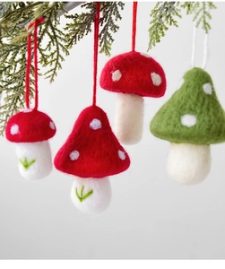 Detail of handmade wool felt mushroom ornaments hanging on pine branches for Xmas