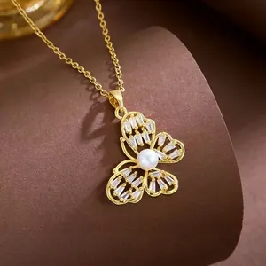 Elegant gold butterfly necklace with inlaid zircon and white pearl on a display stand