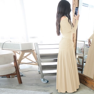 Detail of off-shoulder pleated maxi dress in apricot with slim fit and ruched texture