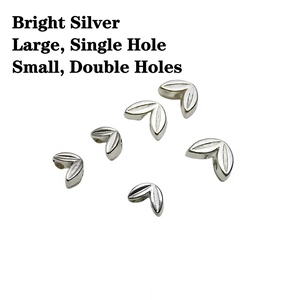 Close-up of bright silver wheat leaf beads in large single hole and small double hole sizes