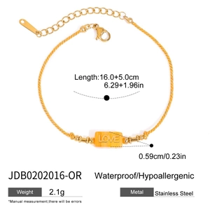 Detailed view of stainless steel bracelet with LOVE engraving on orange stone