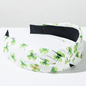 Detail of fabric knotted headband with green clover patterns on white background