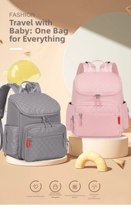 Detail view of pink and grey waterproof diaper backpacks with quilted diamond pattern