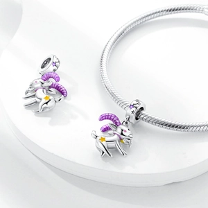 Detailed view of goat charm with purple enamel horns on a silver snake chain bracelet