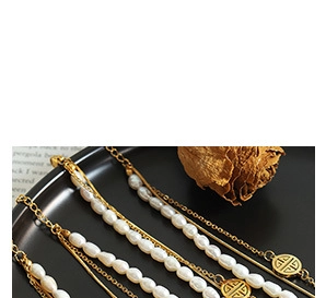 Macro shot of gold-plated twisted ring and pearl accents on elegant black display
